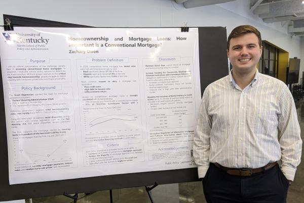 Student posing with research poster