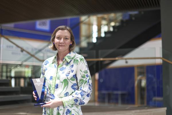 Dr. Cory Curl photographed holding her award at the 2025 Outstanding Teaching Award ceremony. 