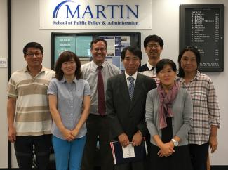 Dr. Kim and IPPMI Cohort in front of Martin School sign