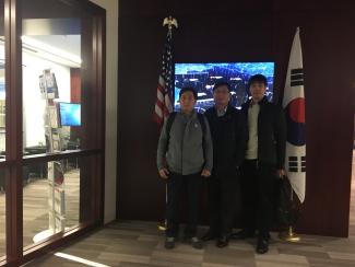 3 IPPMI students in front of Korean and American flags