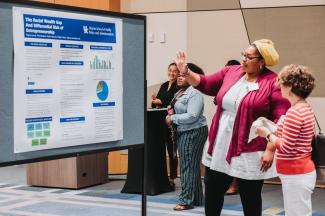 Regina Lewis explains her poster at the UNITE RPA Research showcase 2023