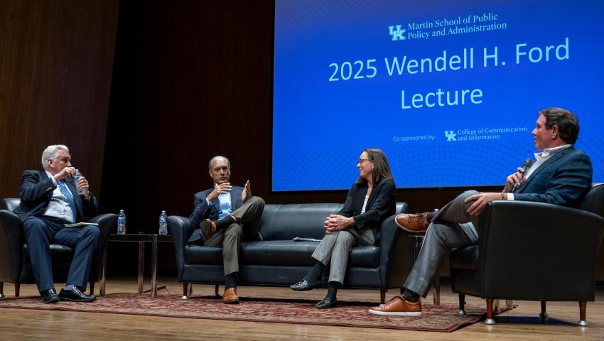 2025 Ford Lecture panelists sitting on couch on stage, candidly discussing NIL during lecture.  