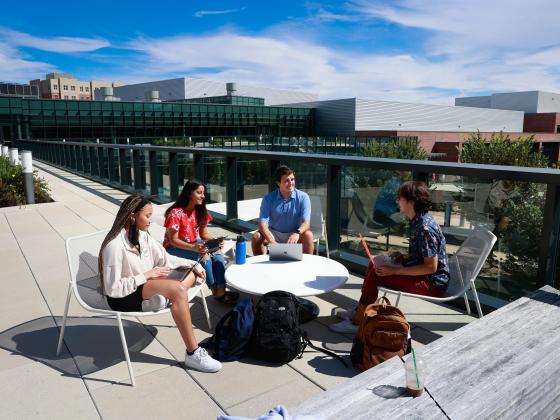 Four students sitting outside of Gatton Student Center studying