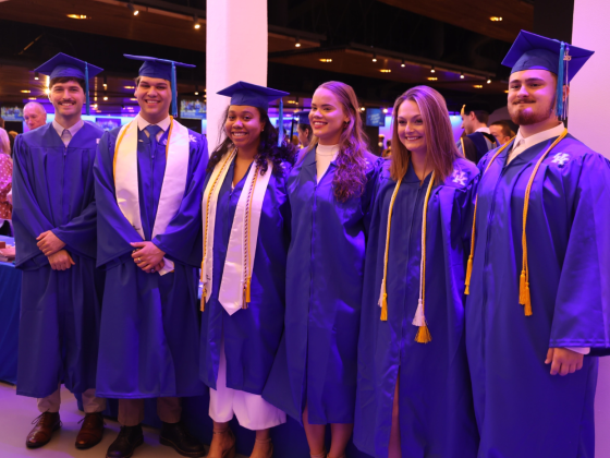 Group of public policy students in graduation robes at commencement in May 2023