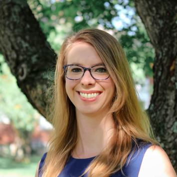 Erin Newell standing in front of a tree.