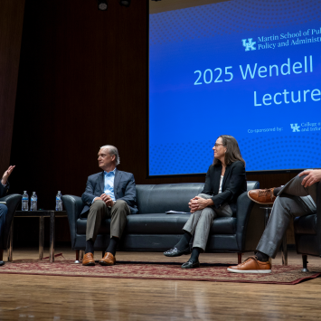 2025 Ford Lecture panelists sitting on couch on stage, candidly discussing NIL during lecture.  