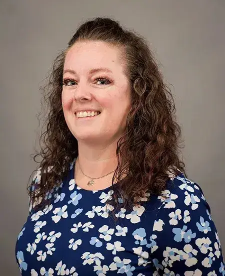 Christina Yantorno smiling and facing the camera in a professional photo studio. 